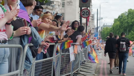 Zeitlupenaufnahme,-Die-Sich-An-Zuschauern-Des-Stolzmarsches-Vorbeibewegt,-Die-Regenbogenfahnen-Schwenken