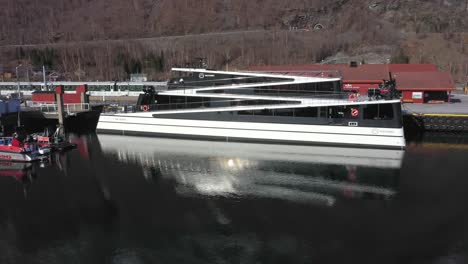 Catamarán-Eléctrico-De-Pasajeros-Con-Un-Diseño-Moderno-único-Inspirado-En-Las-Montañas-Noruegas---Antena-De-Primer-Plano-Del-Amanecer-Del-Barco-Llamado-Futuro-De-Los-Fiordos-Mientras-Se-Encuentra-Junto-Al-Puerto-De-Flam