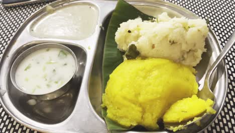 A-beautiful-presentation-of-Idly-and-Upma-on-a-same-plate-and-these-are-served-with-white-chutney