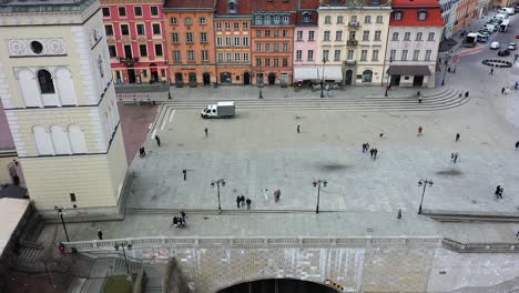 Vista-Aérea-Hacia-Una-Mujer-Tomando-Fotos-En-El-Casco-Antiguo,-Varsovia,-Polonia---Acercándose,-Disparo-De-Drones