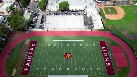 Campo-De-Fútbol-De-La-Escuela-Secundaria-De-Fairfax-Durante-Un-Partido-De-Fútbol---Vista-Aérea-Ascendente-Inclinada-Hacia-Abajo