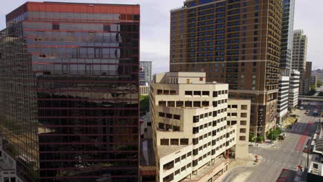 Aerial-view-in-front-of-office-buildings-in-sunny-Austin-city,-USA---ascending,-drone-shot