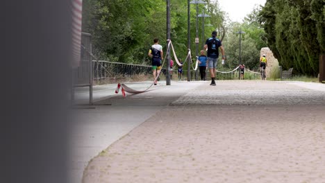 Some-runners-running-a-marathon-on-a-narrow-street-between-trees