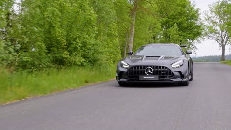 Beautiful-black-sports-car-driving-slowly-on-a-street-dolly-follow-shot