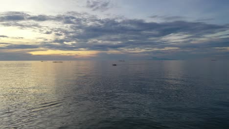 Ein-Himmlischer-Anblick-Des-Ozeans,-Wenn-Die-Wellen-Den-Himmel-Berühren,-Wo-Ein-Boot-Friedlich-Dahinfährt