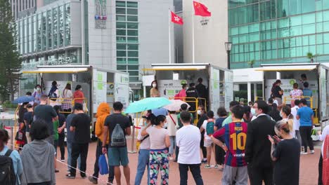 La-Gente-Hace-Cola-Para-Recibir-Pruebas-De-Pcr-Para-El-Coronavirus-De-Los-Camiones-Del-Centro-De-Pruebas-Comunitarias-Para-Abordar-La-Propagación-Del-Virus-Y-Una-Ola-Pandémica-Cerca-Del-Distrito-Financiero-De-Hong-Kong