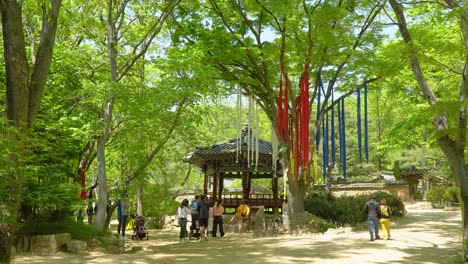 Gente-Caminando-Cerca-De-Seonangdang,-Que-Es-Un-Santuario-Que-Actúa-Como-El-Guardián-Del-Pueblo-En-El-Pueblo-Folclórico-Coreano-En-Yongin-De-Gyeonggi-En-Corea-Del-Sur