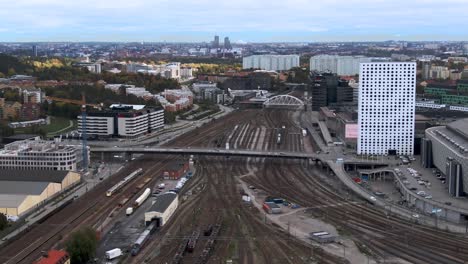 Toma-Panorámica-Aérea-Sobre-El-Patio-Ferroviario-De-Solna-Y-Vista-De-Estocolmo,-Suecia