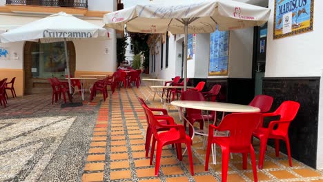 Typical-Spanish-street-in-old-city-Marbella-with-white-houses,-church-and-restaurants