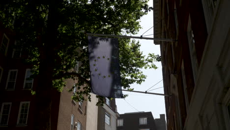 Disparo-De-Una-Bandera-De-La-Unión-Europea-Colgando-Fuera-De-La-Casa-De-Europa-En-Westminster,-Londres,-Inglaterra