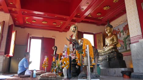 A-Man-Sitting-on-The-Floor-and-Pray-In-Front-Of-The-Big-Golden-Buddha