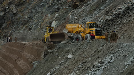 Soldados-Observando-Las-Excavadoras-Limpiando-Las-Secuelas-Del-Deslizamiento-De-Tierra-Que-Bloquea-La-Autopista-Karakoram-En-El-área-De-Dasu,-Pakistán