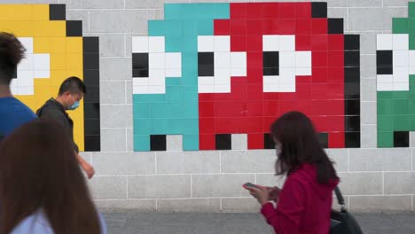 Se-Ve-A-Los-Peatones-Pasando-Por-Un-Arte-De-Wall-Street-Que-Representa-El-Clásico-Juego-De-Arcade-Pac-man-En-Hong-Kong.