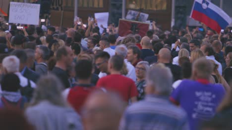 Crowd-Of-People-Rallying-Against-Strict-Anti-COVID-Rules-with-Flags-and-Smartphones-In-Ljubljana,-Slovenia