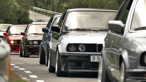 Procesión-Del-Club-De-Coleccionistas-Clásicos-Bmw-E30-Vehículos-Que-Viajan-A-Lo-Largo-De-La-Carretera-Forestal-Que-Pasa-Cerca