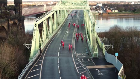 Charity-Santa-dash-fun-run-over-Runcorn-Silver-Jubilee-bridge-Aerial-view-slowly-tilting-upwards