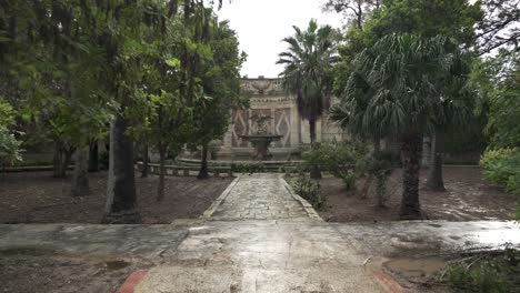 Walking-Towards-Fountain-with-Wild-Chickens-and-Chicks-Pecking-Bread-on-a-Rainy-Day-in-Malta