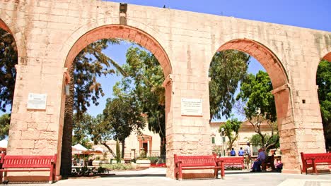 Tourists-enjoy-the-shade-of-the-ancient-arches-in-the-Upper-Barrakka-Gardens---Valletta-Malta-on-a-bright-sunny-day---Travel-and-Tourism