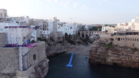 Aerial-over-Polignano-A-Mare-beach,-Bari,-Italy,-summer-evening