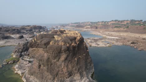 Panorámica-Aérea-Avanzando-Tiro-De-Agua-Y-Grandes-Rocas-En-India