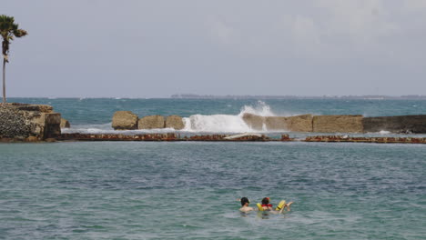 Couple-swim-together-while-snorkelling-in-calm-waters-of-San-Juan,-Puerto-Rico