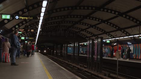 Two-metro-trains-arriving-at-Stortinget-station-with-passsengers-disembarking-and-embarking