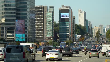 Tráfico-De-Automóviles-En-La-Carretera-Yeongdong-daero-Cerca-Del-Centro-De-Comercio-Mundial-Coex-Seúl-Corea-Del-Sur,-Torre-Asem,-Enormes-Carteles-De-Exhibición-De-Medios-De-Fachada-Al-Aire-Libre-En-Las-Paredes-Del-Edificio