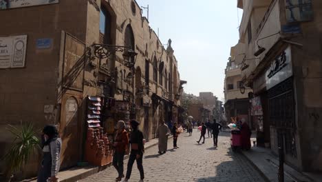 Egyptian-people-walking-in-pedestrian-street-of-old-Cairo-historic-town-center,-Egypt