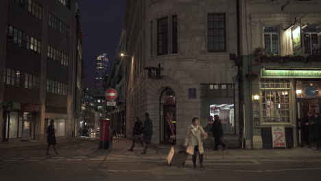 Asian-female-tourist-jaywalk-London-street-with-luggage-surrounded-by-black-cab,-moped,-and-e-scooter