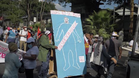 Protesters-carry-a-banner-with-an-offensive-depiction-of-the-current-president-Nayib-Bukele---Slow-Motion