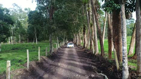 Toma-Aérea-De-Un-Porsche-Cayman-En-Movimiento-En-Caminos-De-Grava-Del-País-Colombiano