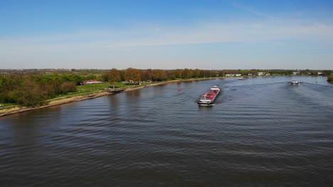 Aerial-View-Of-Cornelis-R-Cargo-Ship-Approaching-In-The-Distance-Along-Oude-Maas-On-18-April-2022