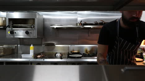 Young-male-chef-preparing-breakfast-in-commercial-kitchen-setup