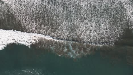 Aerial-view-of-waves-crashing-upon-shore-in-Dominical-Beach-in-Costa-Rica,-bird-eye-wide-shot