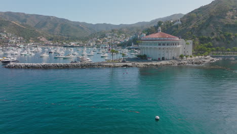 Flying-Above-Bright-Blue-Waters-of-Catalina-Island,-Pacific-Ocean-Below-and-Mountains-Ahead