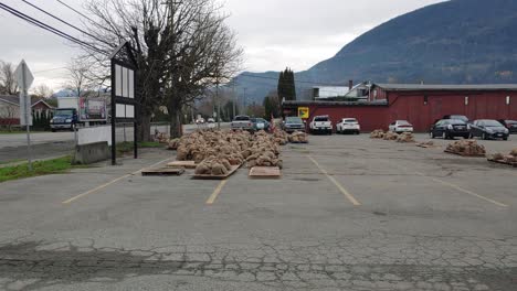 Una-Toma-Que-Revela-Sacos-De-Arena-Almacenados-En-Un-Estacionamiento-De-Automóviles,-La-Comunidad-De-Abbotsford-Recibe-Suministros-Básicos-De-Emergencia-Para-Proteger-La-Propiedad-Del-Aumento-De-Las-Inundaciones-En-Columbia-Británica,-Canadá