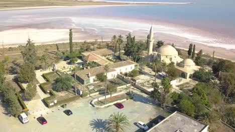 Orbit-Shot-Of-Sultan-Hala-Tekke-Mosque-Surrounded-By-Stunning-Salt-Lake-,-Larnaca-City-,-Cyprus