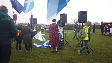 Ein-Stewart-Hilft-Einem-Mann-Im-Kompletten-Schottischen-Highland-Outfit