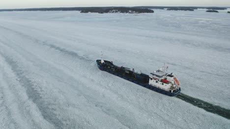 Aerial-tracking-view-of-oil-and-chemical-tanker-CRYSTALWATER-call-sign-ESLI-moving-ahead-in-ice-covered-Finnish-archipelago