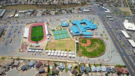 Vista-Aérea-De-Drones-Volando-En-Círculos-Sobre-El-Campus-De-La-Escuela-Secundaria-En-El-Oeste-De-El-Paso,-Texas,-Con-Un-Campo-De-Fútbol-Y-Un-Campo-De-Béisbol-A-La-Vista