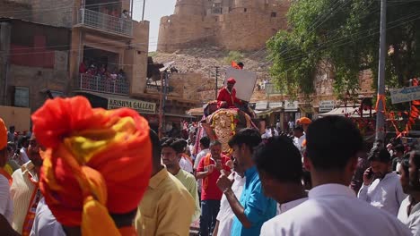 Un-Hombre-Se-Sienta-Encima-Y-Trata-De-Controlar-Al-Elefante-En-La-Multitud-De-Personas