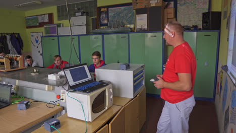 Profesor-De-Secundaria-Vocacional-Presentándose-En-Un-Salón-De-Clases-Lleno-De-Jóvenes-Estudiantes-Sentados-Y-Escuchando-En-Sus-Computadoras