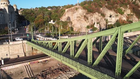 Aerial-backward-dolly-on-tram-passing-across-beautiful-famous-bridge