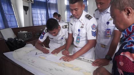 Student-study-RYA-course-with-sailing-map-charts-use-Almanacs-and-Pilotage-with-chart-reading-and-plotting-by-using-protractors-and-dividers-Nautical-education