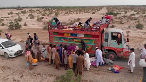 Para-Ayudar-A-Las-Víctimas-De-Las-Inundaciones-Que-Han-Sido-Reubicadas-Y-Dañadas-Por-La-Reciente-Inundación-En-Pakistán,-Las-Personas-Están-Dando-Comida-En-Camiones