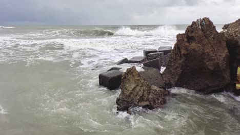 Aerial-slow-motion-shot-of-sea-waves-crashing-in-the-rocks-in-Manali-city