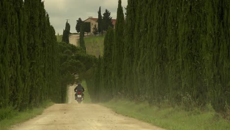 Mann-Fährt-Bei-Strahlendem-Sonnenschein-Mit-Dem-Motorrad-Zu-Einem-Wunderschönen-Landgut-In-Der-Toskana