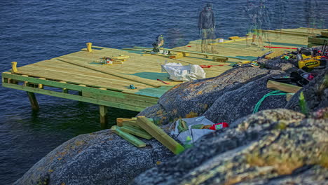 Men-At-Work-Constructing-Wooden-Pier-On-Rocky-Shore