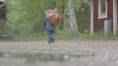 Clima-Extremo---Un-Niño-Con-Un-Paraguas-Corre-Bajo-La-Fuerte-Lluvia