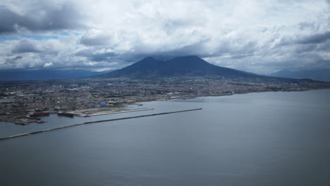 Hiperlapso-Aéreo-De-Nubes-Volando-Sobre-El-Monte-Vesubio-Mientras-Los-Barcos-Pasan-Por-El-Agua